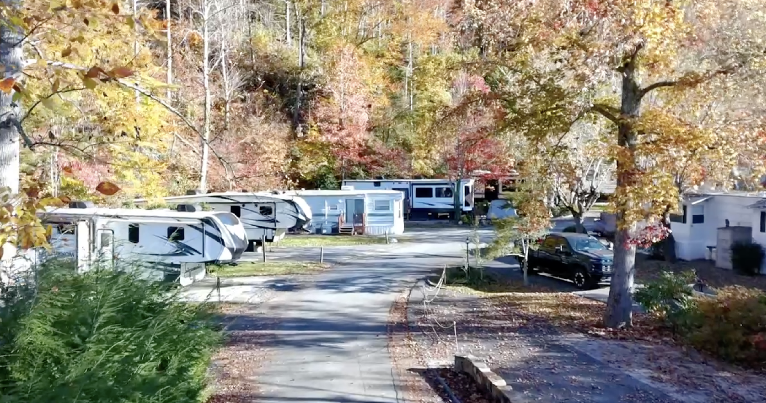 Aerial view of RVs and fifth wheels along a tree-lined road at Outdoor Resorts Gatlinburg in fall